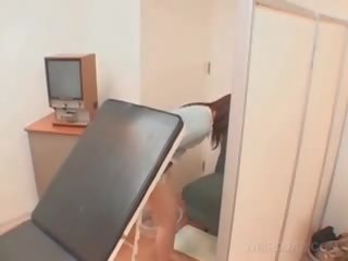 Ázijské pacient kurvička opened s lekárske zrkadlo na the lekárske osoba