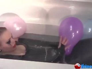 Latex angezogen fräulein mit luftballons im ein badewanne